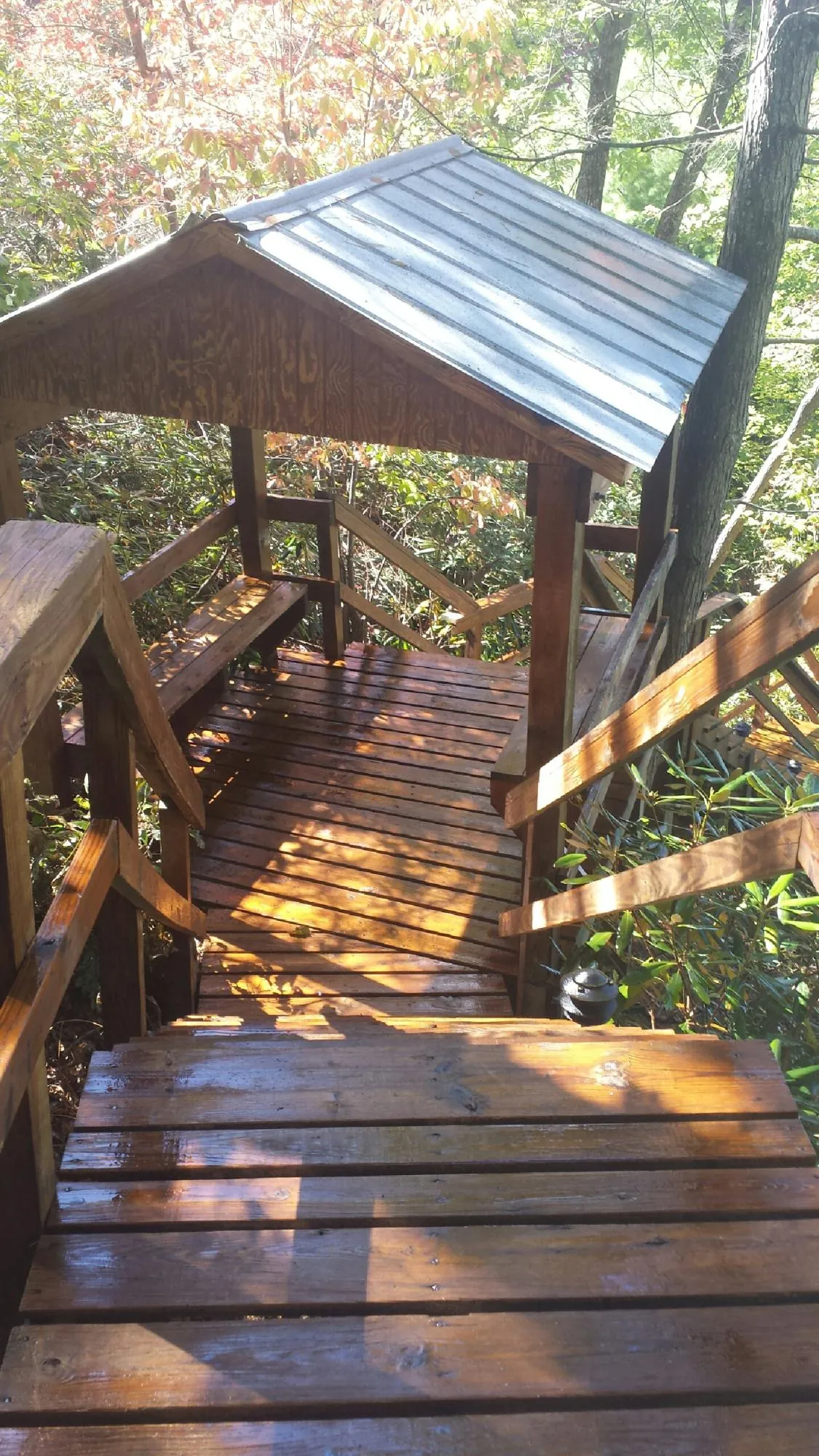 Freshly stained wood walkway and covered shelter with a metal roof in Hauppauge