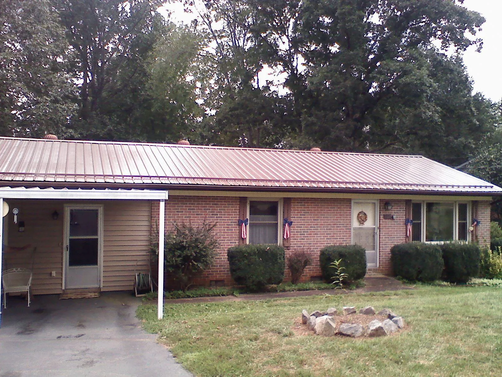 Bronze metal roof and carport on a brick ranch home — Roof Repair work by our crew in Hauppauge
